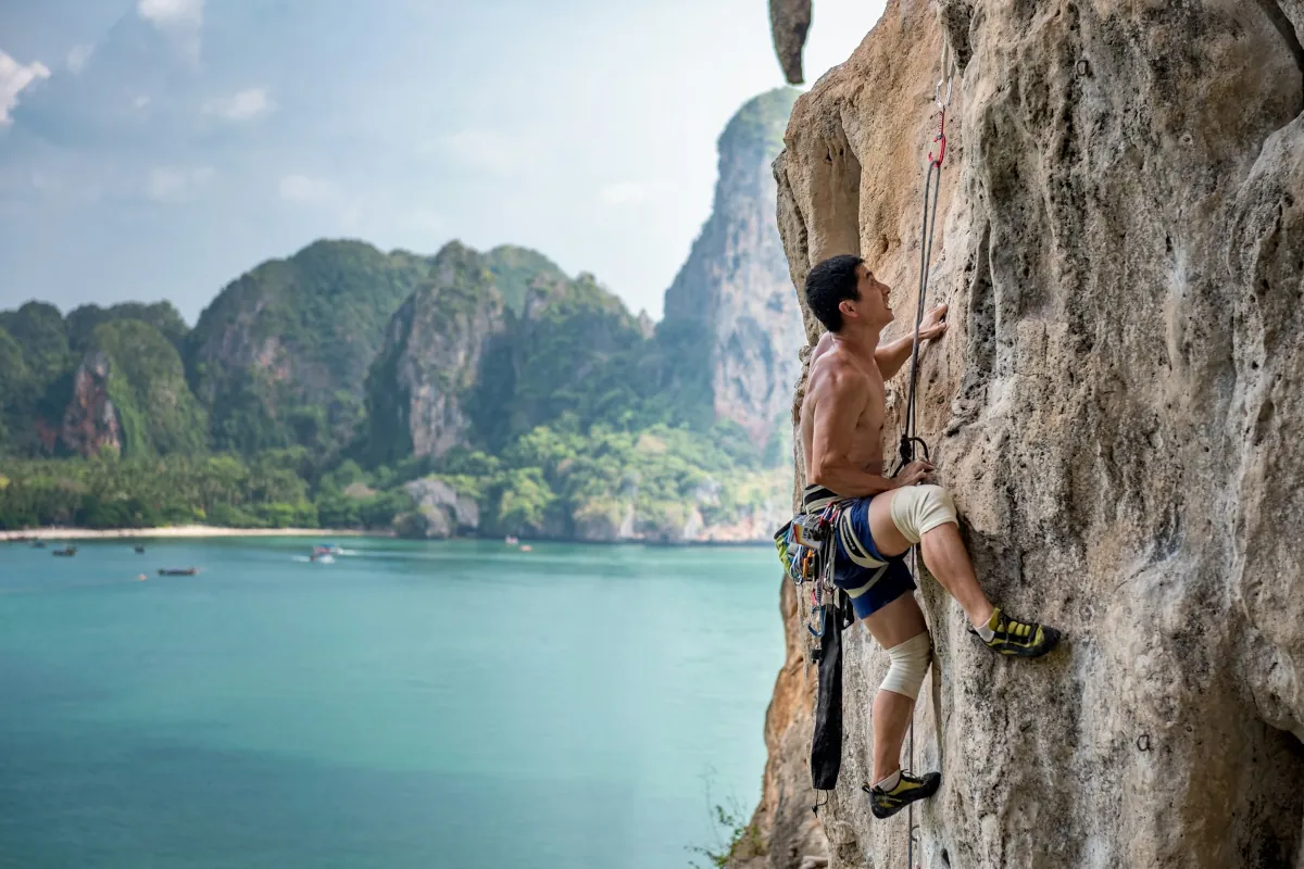 Man die een rots beklimt in Krabi Railay