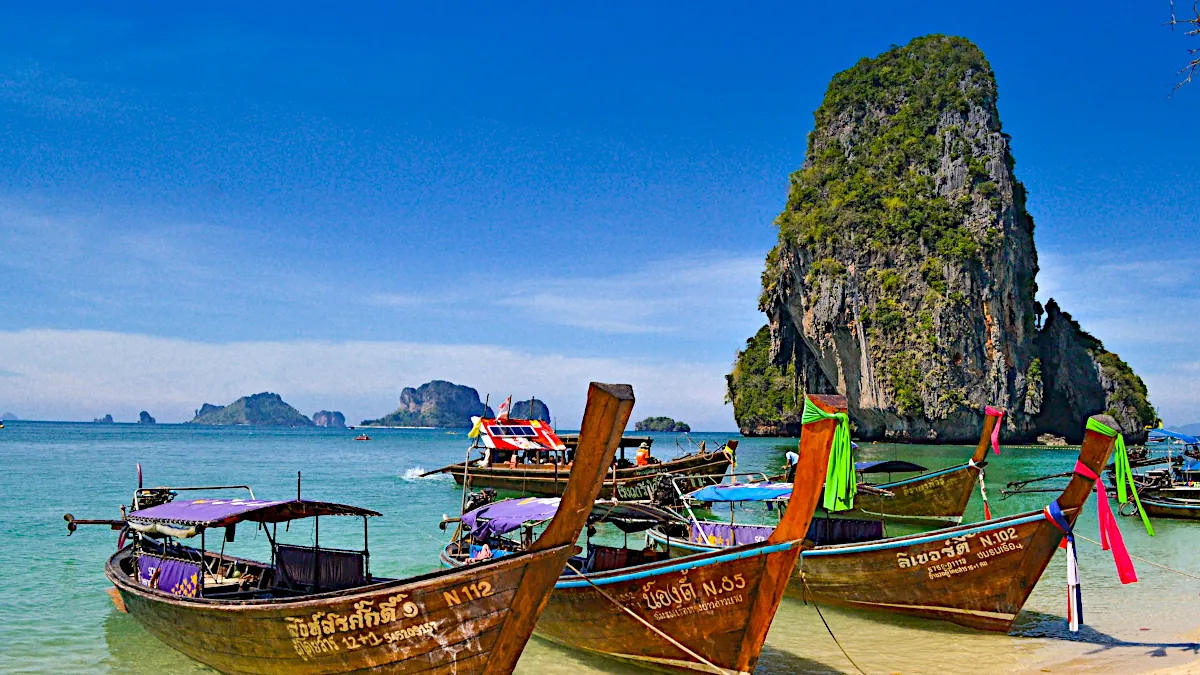Krabi longtail boats on beach with rock island in the background